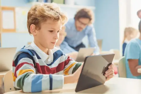 Schüler lernen mit Tablets und Laptops. Digitale Medien in der Schule fördern interaktives Lernen.